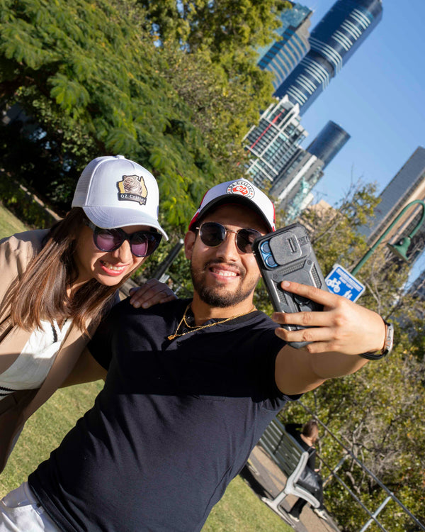 Two people taking a selfie with a cityscape in the background