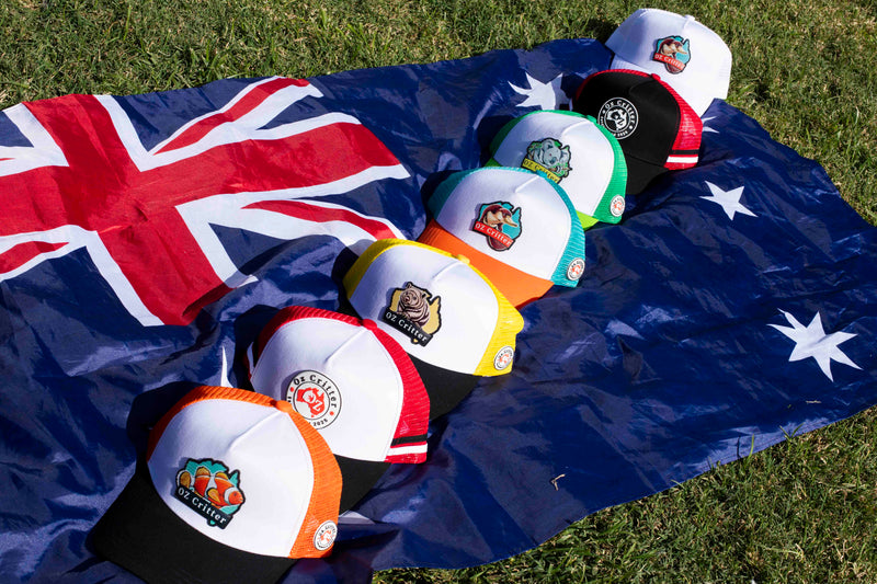 Collection of critter caps with OZ Critter logos on an Australian flag