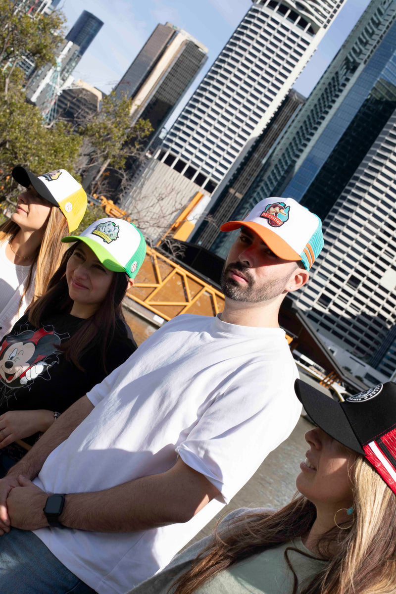 People wearing colorful baseball caps with a cityscape in the background.
