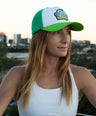 Woman wearing a green and white koala cap with a cityscape in the background